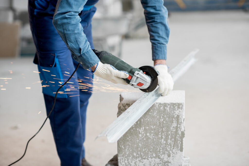 Builder cutting metal indoors