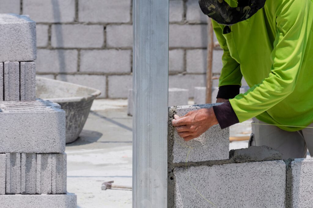 Builder worker hand setting nylon level line for building brick wall in house construction site