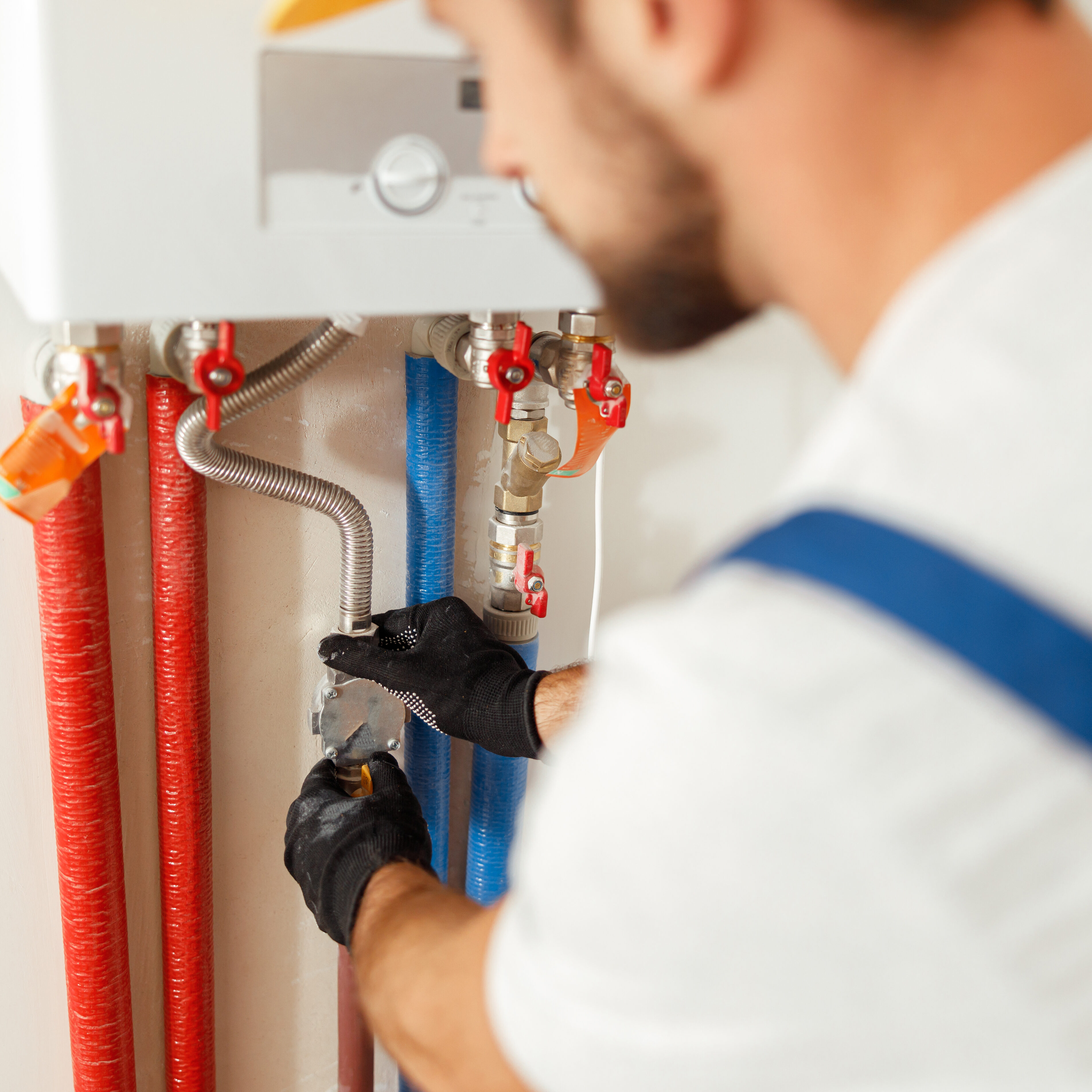 Closeup of plumber working with water pipes while installing heating system in apartment